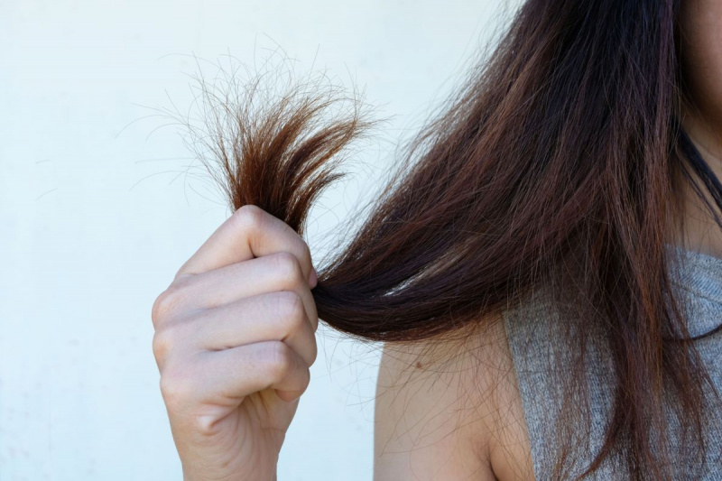 Imagem recortada de mulher segurando o cabelo