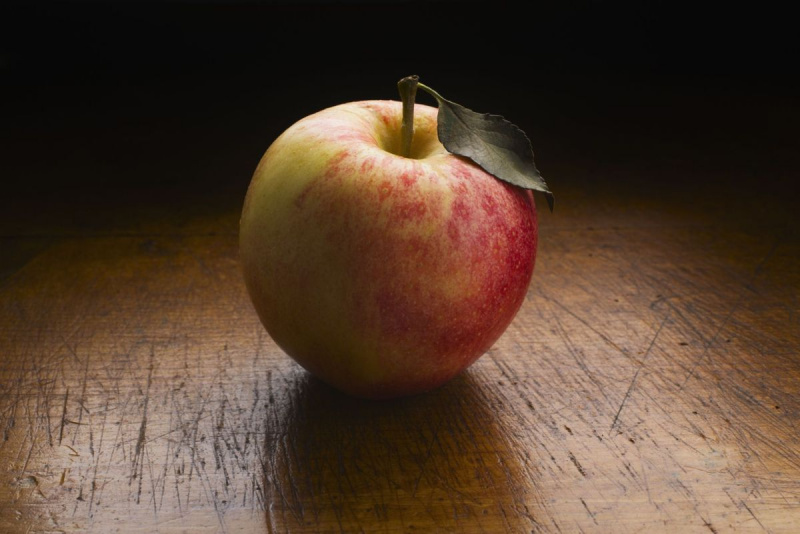 تفاحة على طاولة خشبية