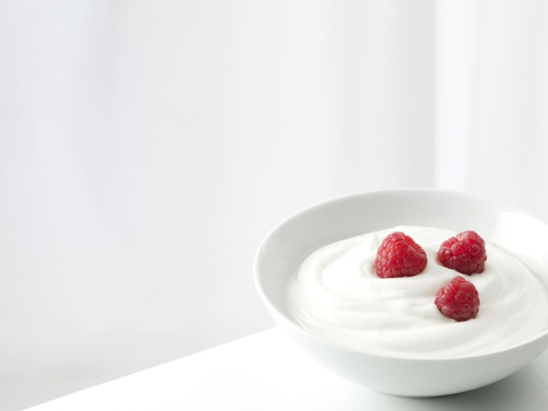 Iogurte com framboesas em uma tigela branca