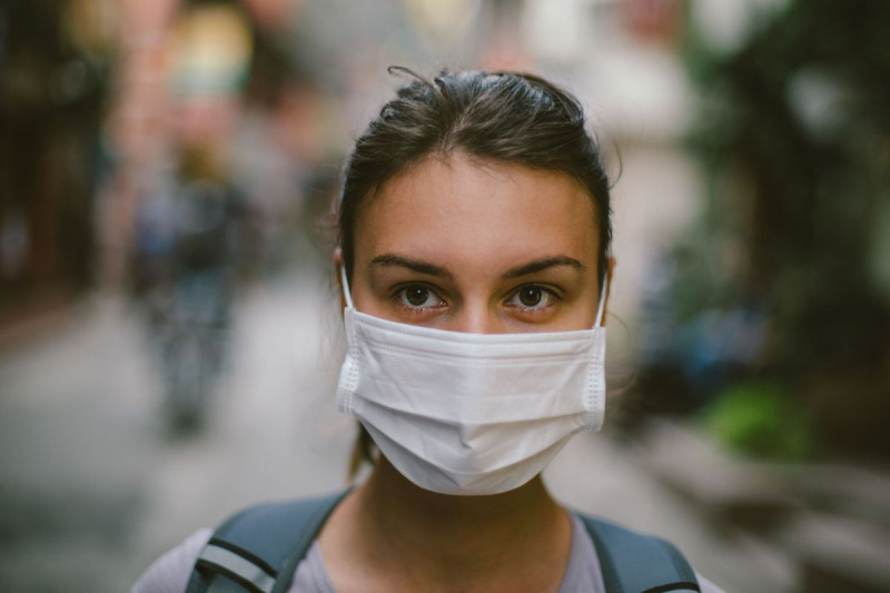 Ung kvinde med ansigtsmaske på gaden
