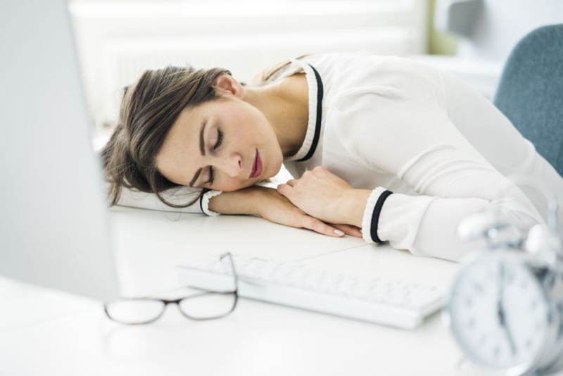 Претоварена жена спи на бюро в офиса