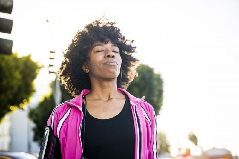 امرأة سوداء تناسب الشباب تستمع إلى الموسيقى أثناء التمرين