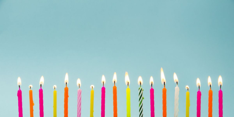 Daugybė skirtingų spalvų formų ir raštų gimtadienio žvakių, degančių mėlynai, rinkinys. Su gimtadieniu atviruko dizaino koncepcija. Apatinis apatinis kraštas turi daug vietos kopijavimui.