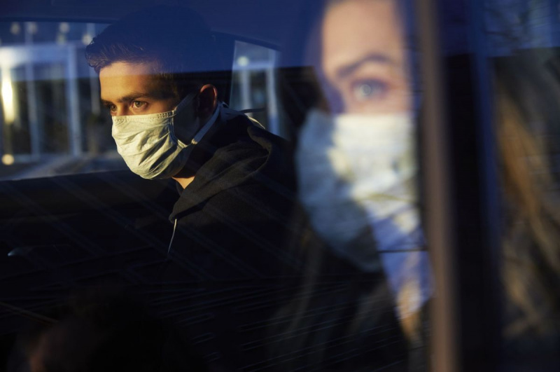 jovem e mulher no carro usando máscaras protetoras de vírus