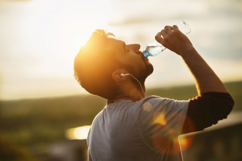Снимка на млад мъж, който пие вода