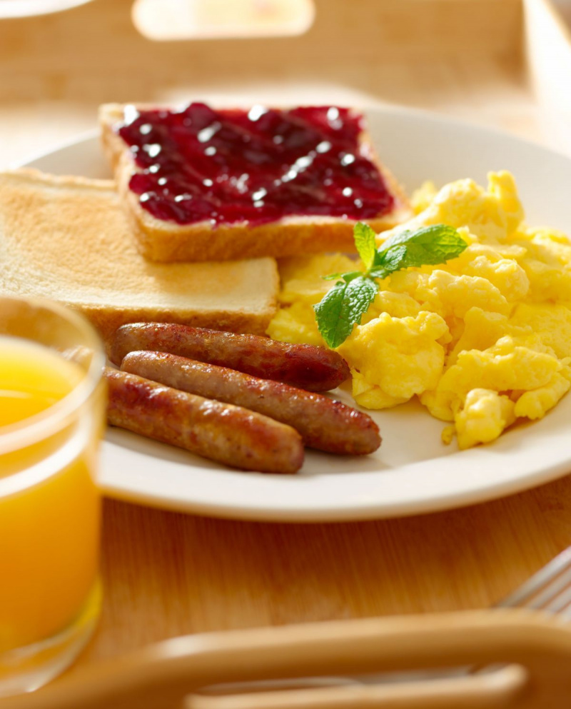 raňajky s miešanými vajíčkami, klobásovými článkami a toastom.