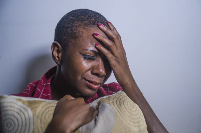 जीवन शैली के अंदर युवा उदास और उदास काले अफ्रीकी का छायादार चित्र घर के फर्श पर बैठी अमेरिकी महिला हताश और चिंतित महसूस कर रही है नाटकीय प्रकाश में दर्द और अवसाद पीड़ित है