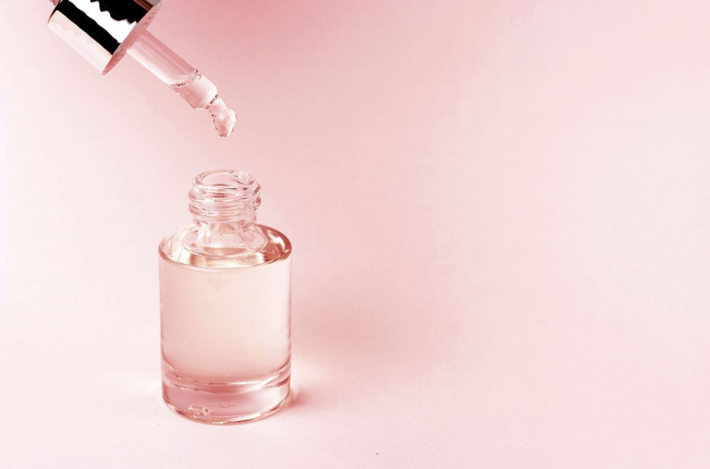 soro e conta-gotas em um fundo rosa close-up, conceito de cosméticos naturais