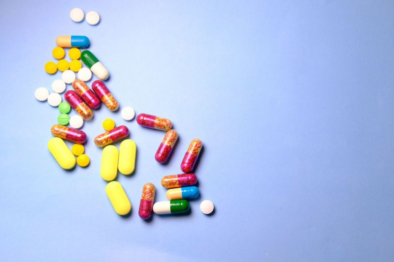 منظر علوي لحبوب وأقراص وكبسولات الأدوية الصيدلانية على خلفية زرقاء